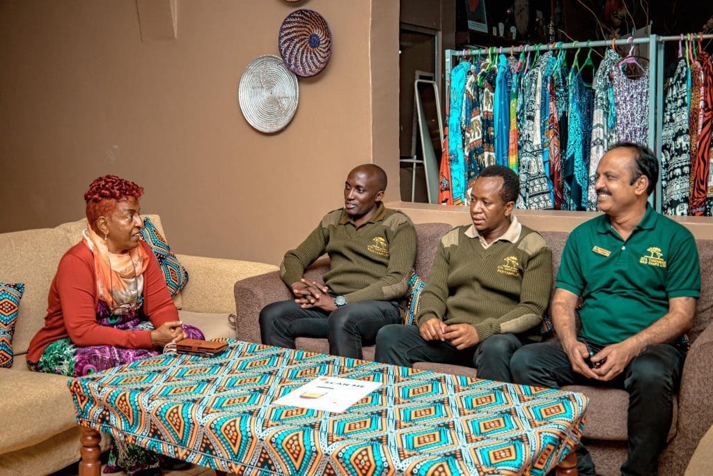 Mama Zara talking with ZITA Tanzania Wild Camps staff in a lounge.